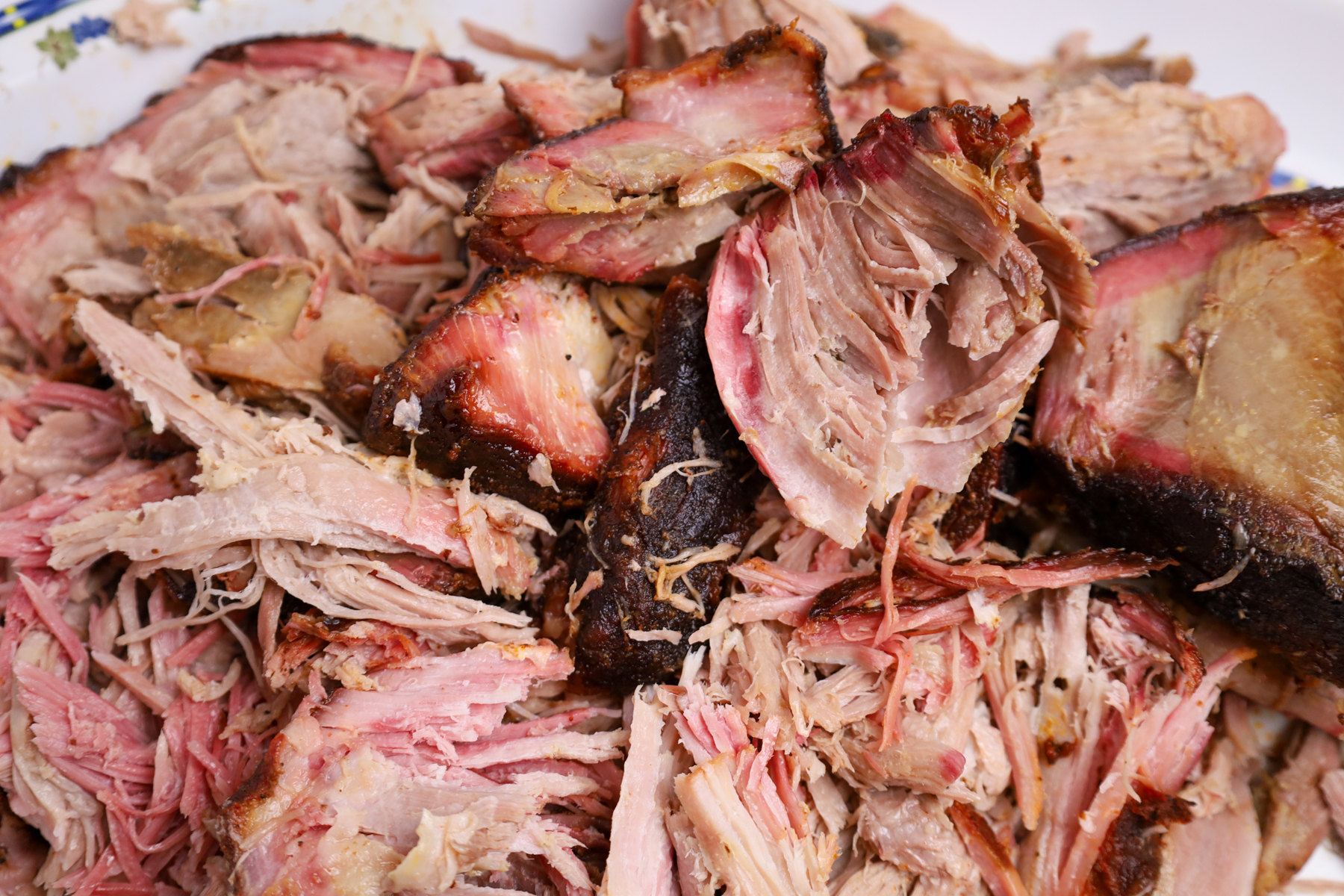 A succulent smoked Boston butt with a beautiful smoke ring that is rich and has a flavorful crust.