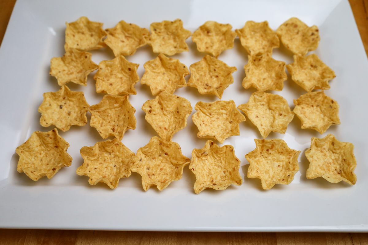 Corn chips arranged on a platter, ready for topping.