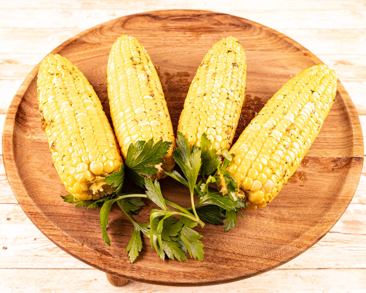 Four ears of corn on the cob fully smoked and lightly seasoned.
