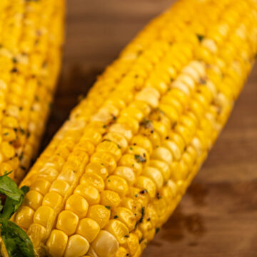 Smoked corn on the cob, with a golden-brown finish and hints of spices.